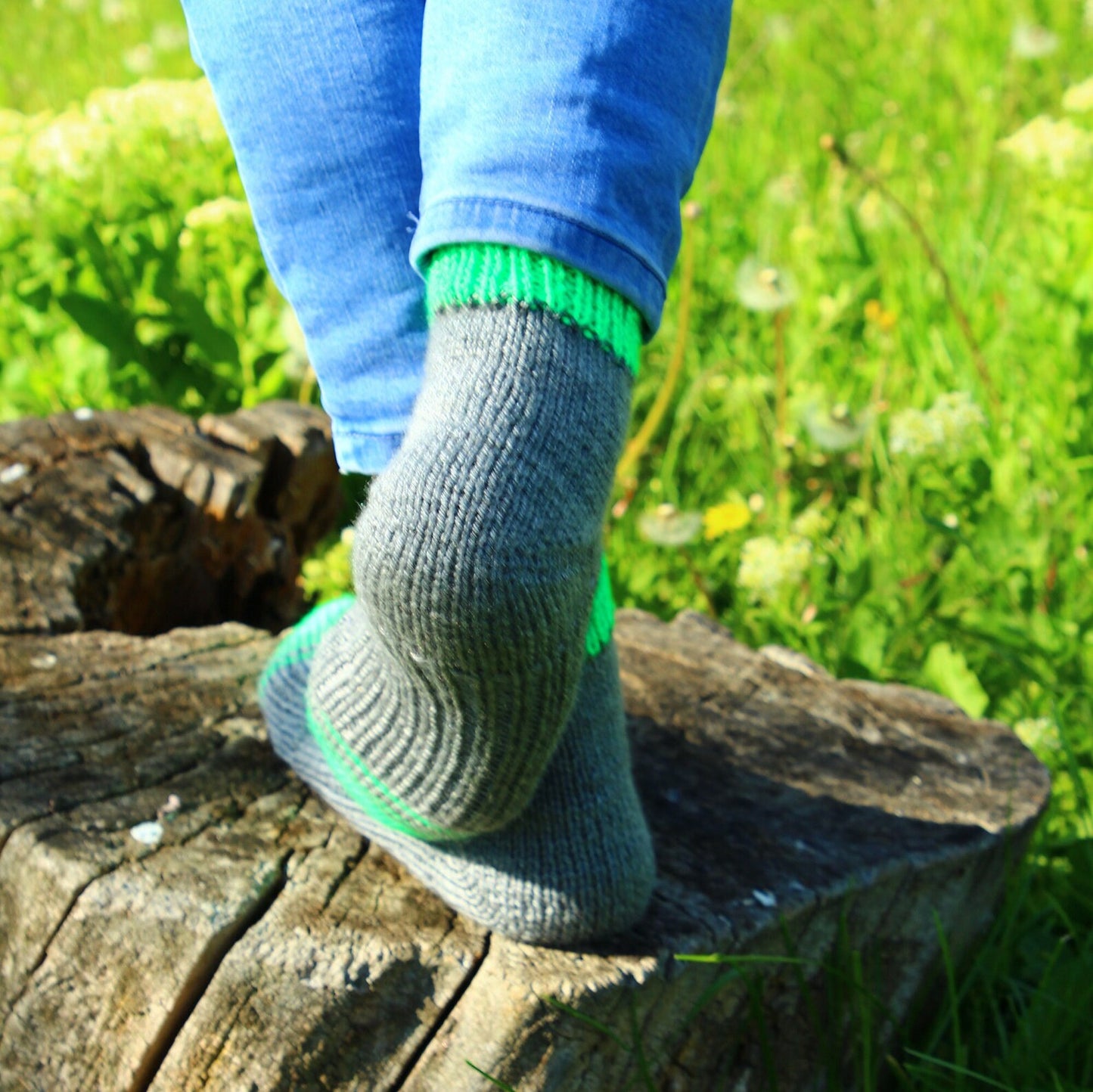 Close-up of gray and green acrylic socks showing detailed knit patterns