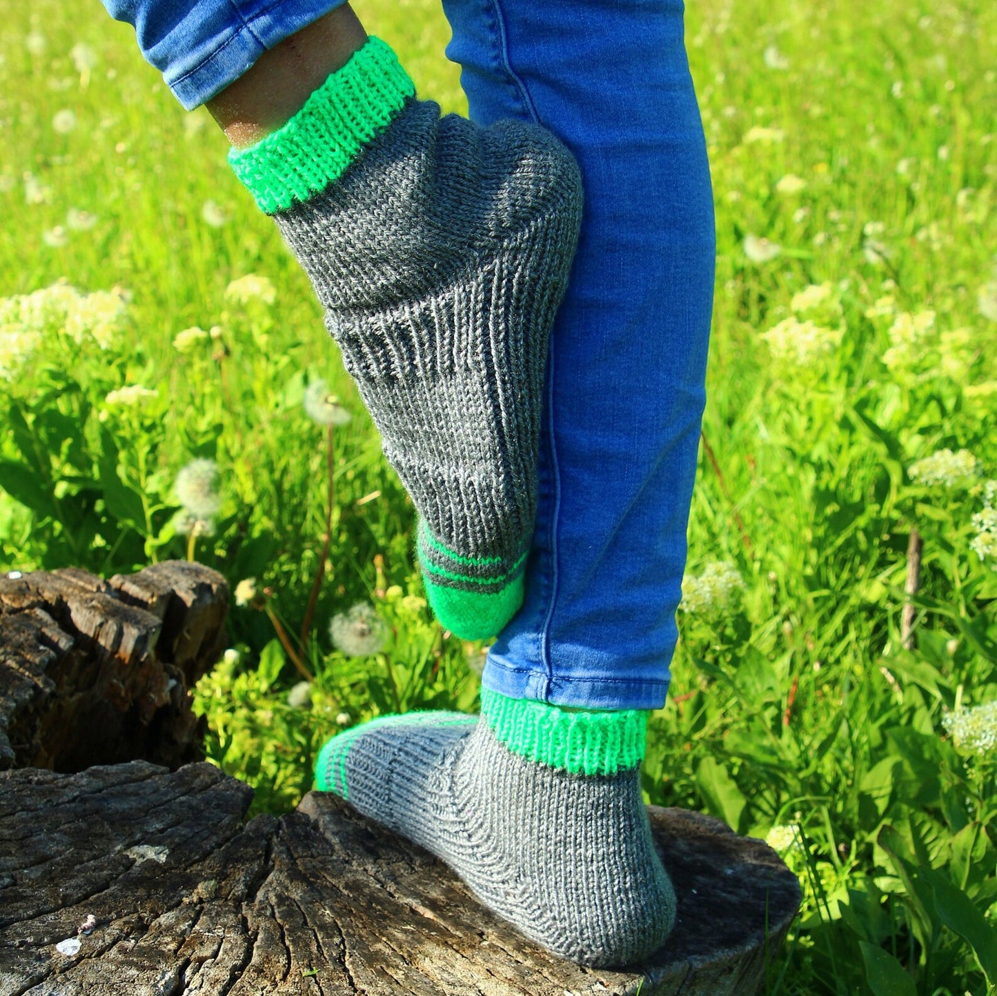 Comfortable and breathable hand-knitted socks on a background of lush green grass